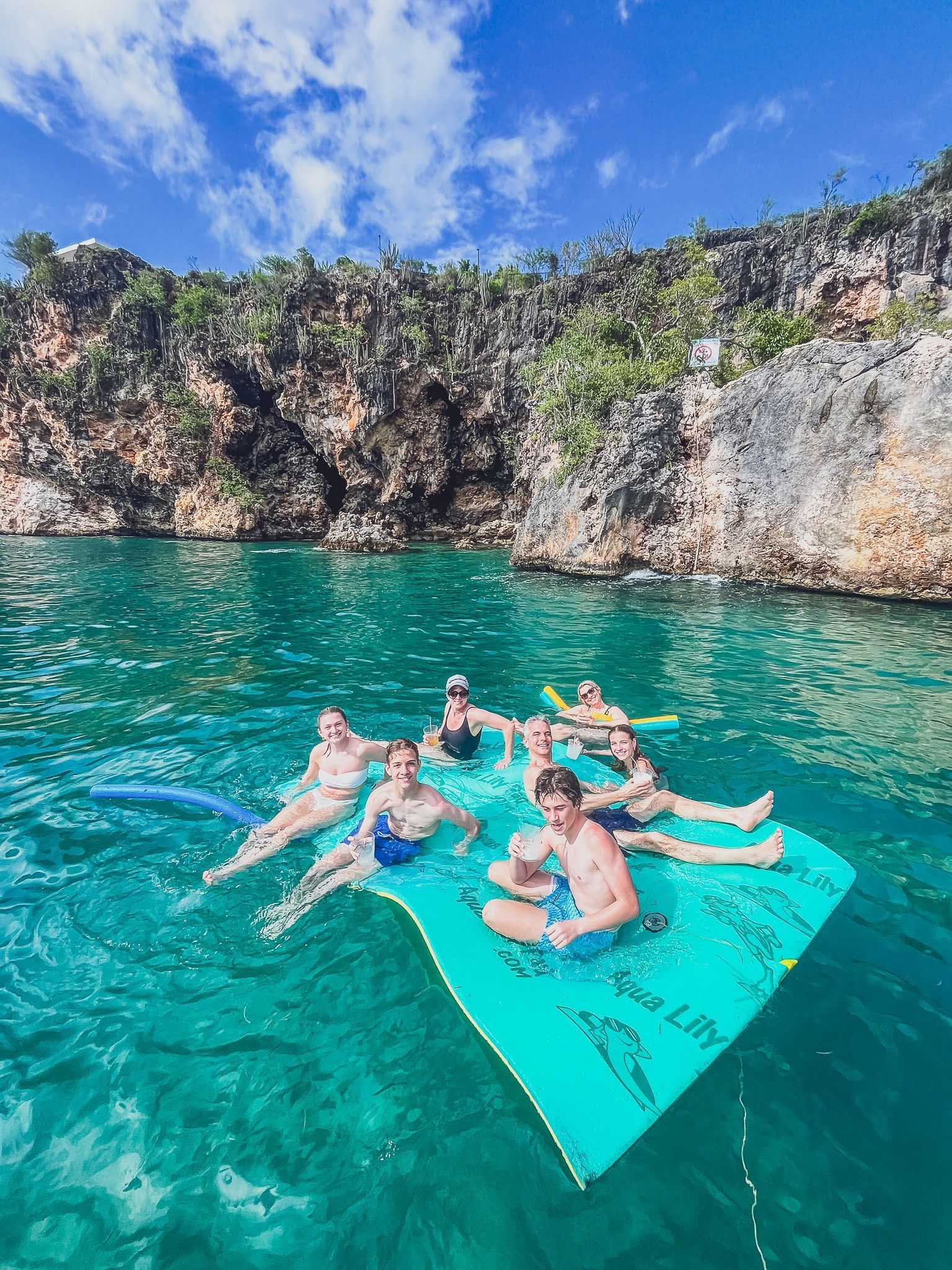 A group of people are floating on a raft in the water.