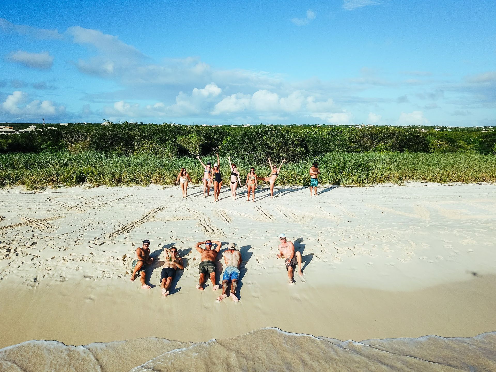 A group of people are standing on a beach.