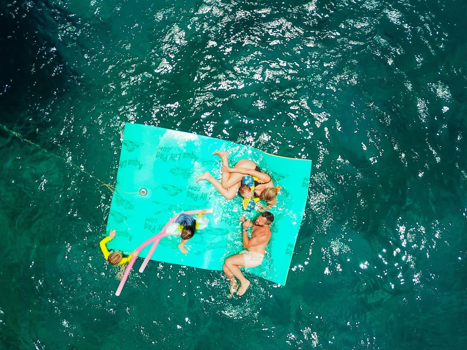 A group of people are floating on a raft in the ocean.