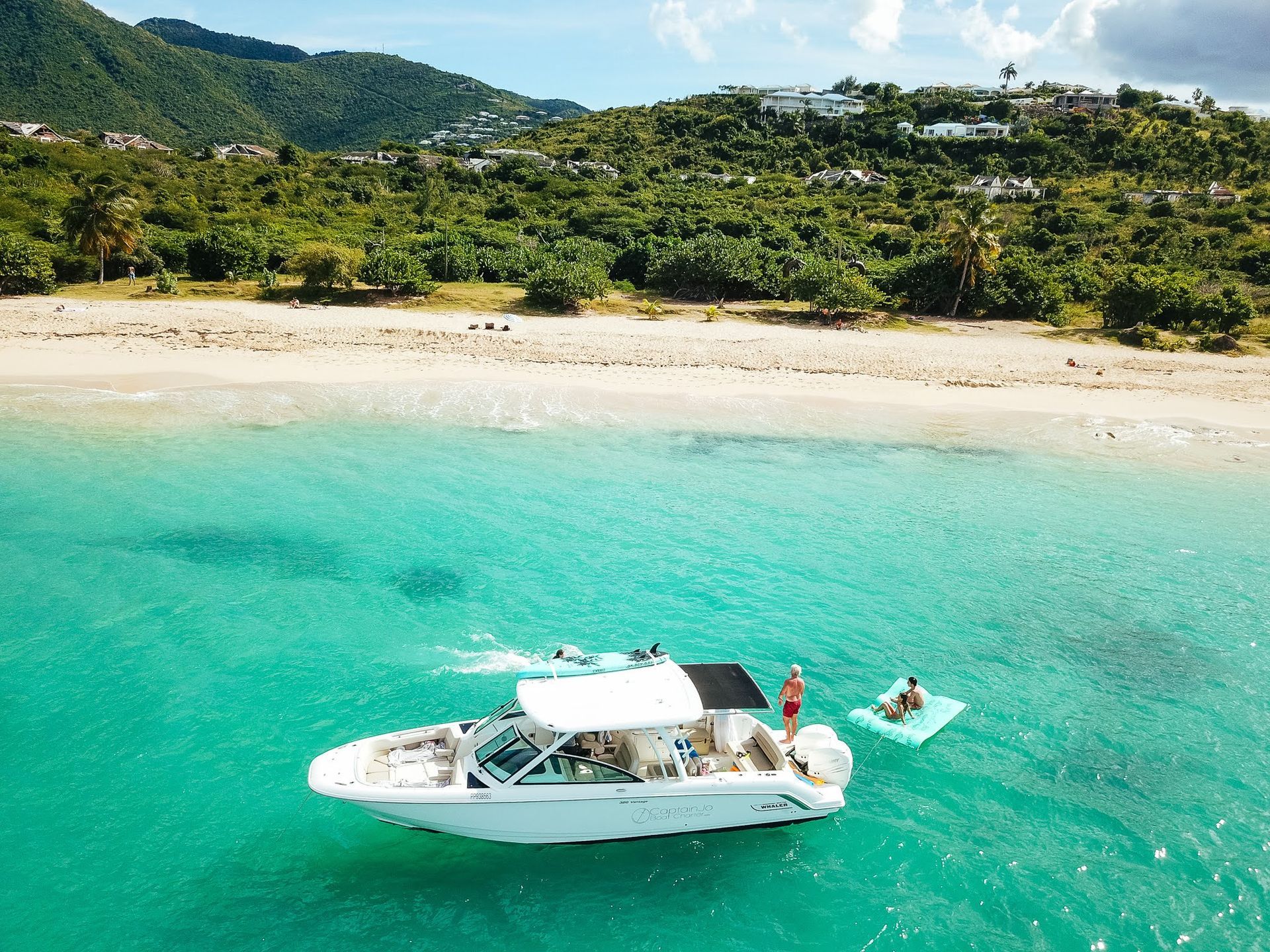 An aerial view of a boat in the ocean near a beach.