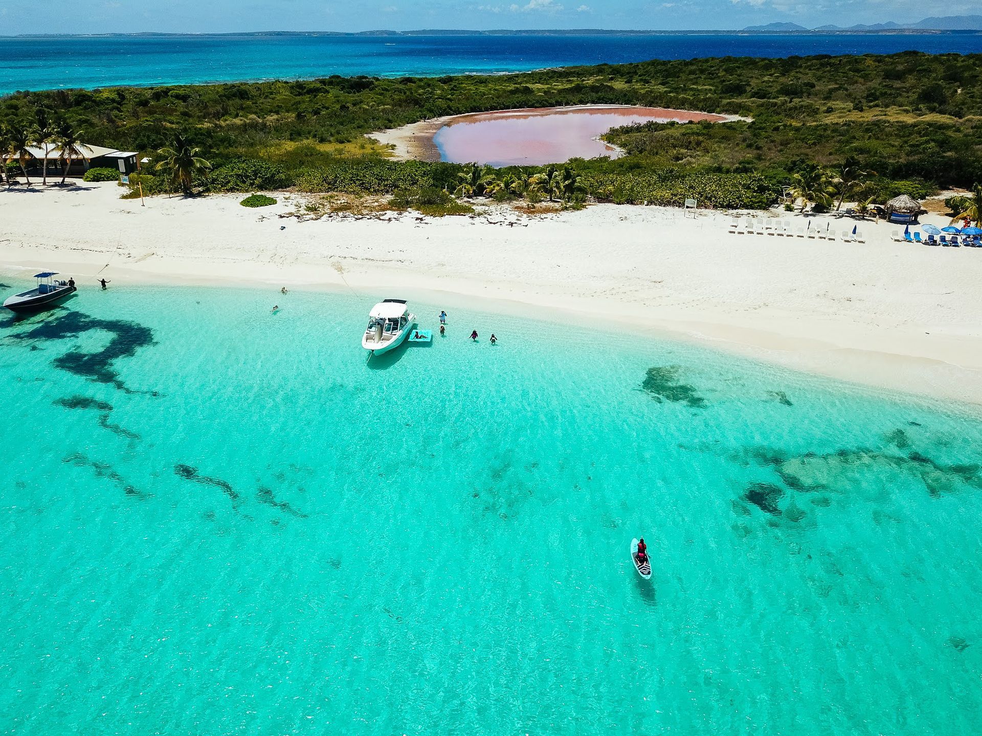 An aerial view of a beach with boats in the water.