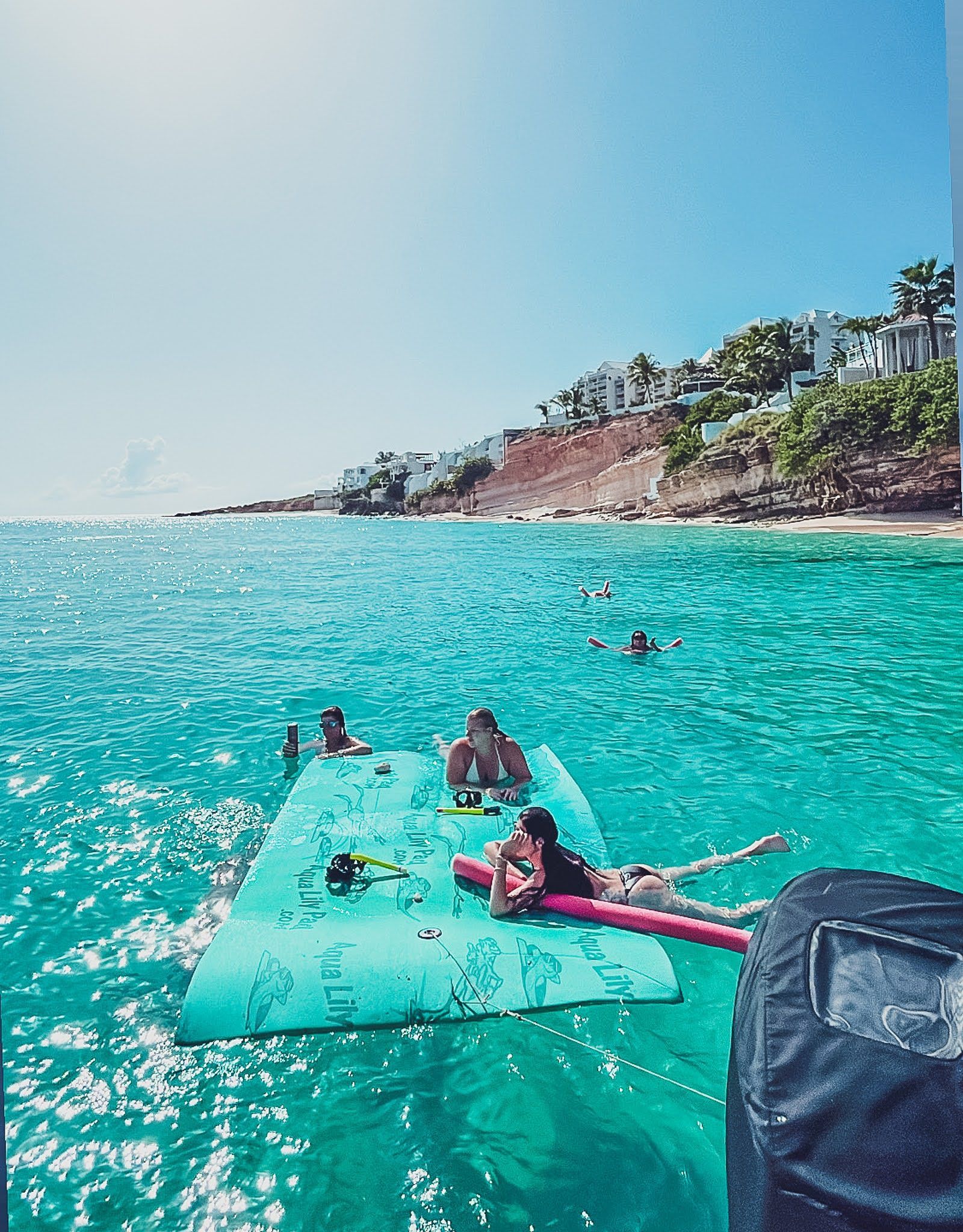 A group of people are floating on a raft in the ocean.