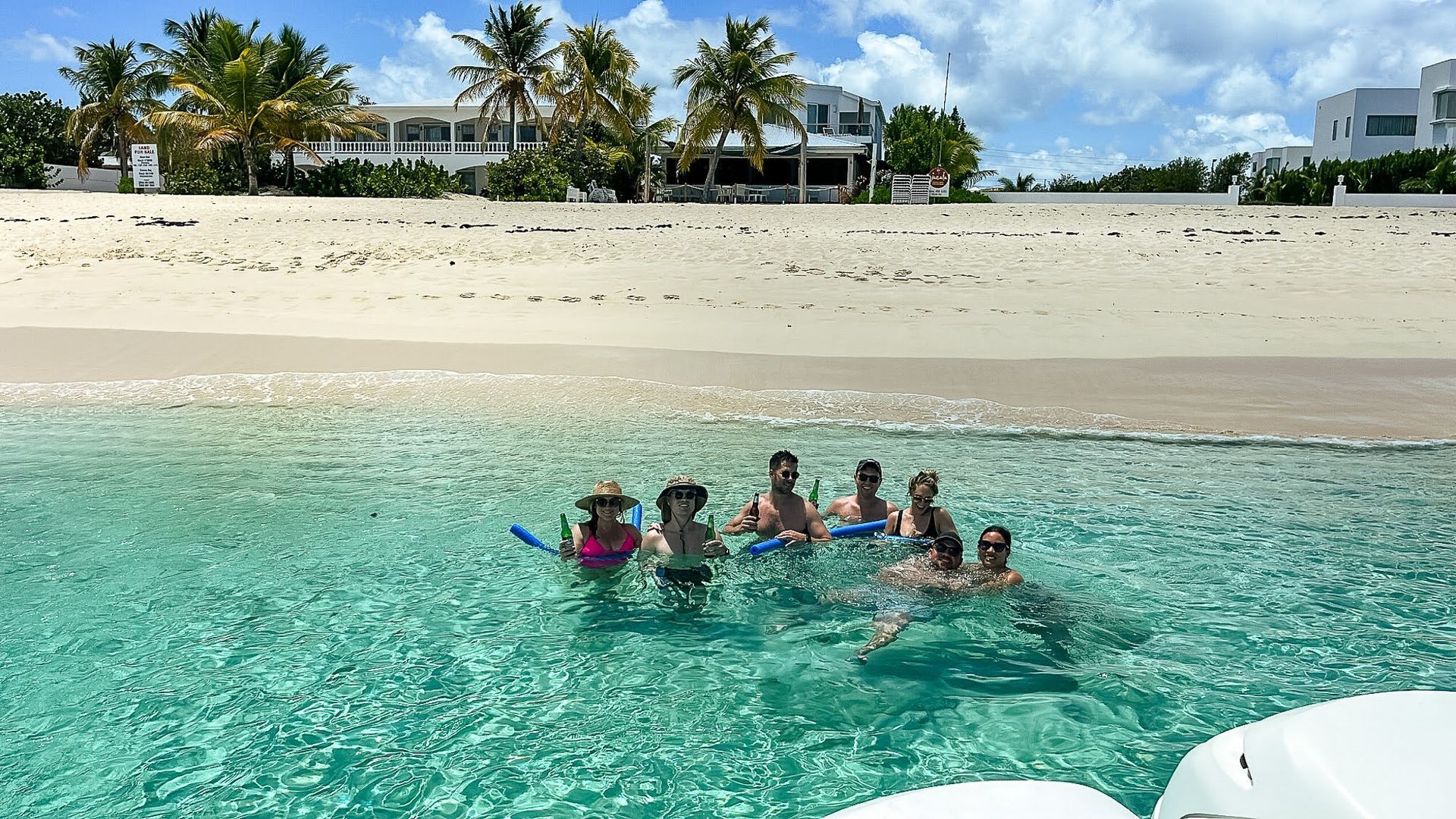 A group of people are swimming in the ocean near a beach.