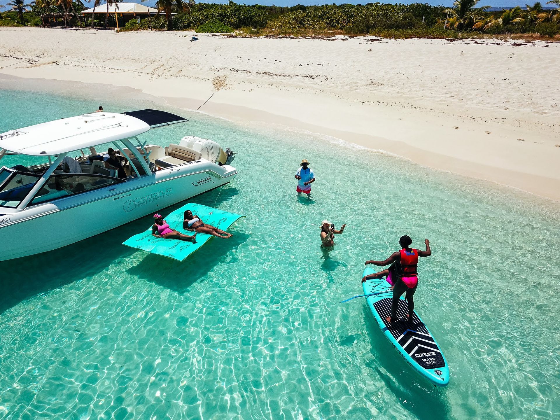 A group of people are swimming in the ocean next to a boat.