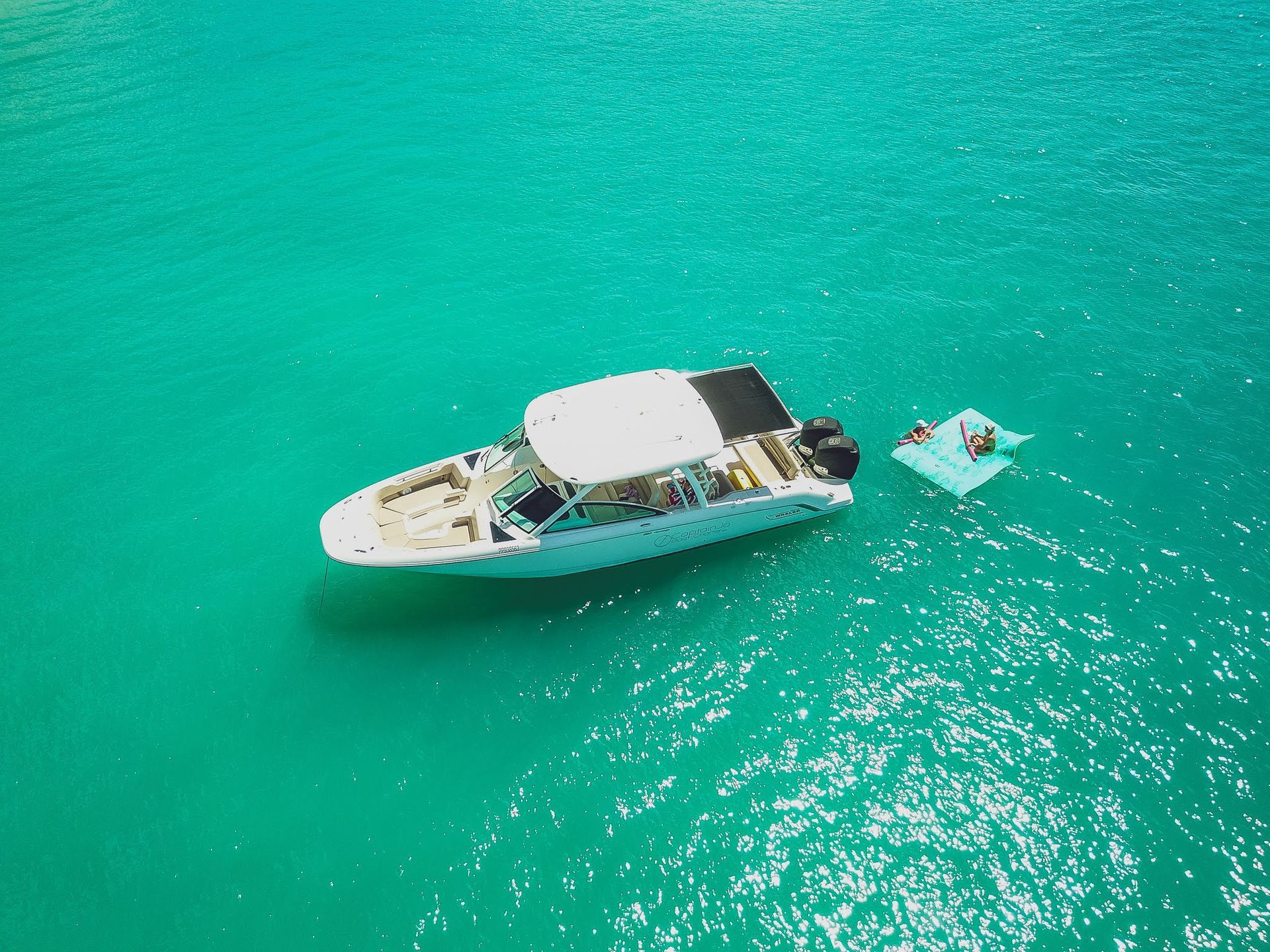 An aerial view of a boat and a raft in the ocean.