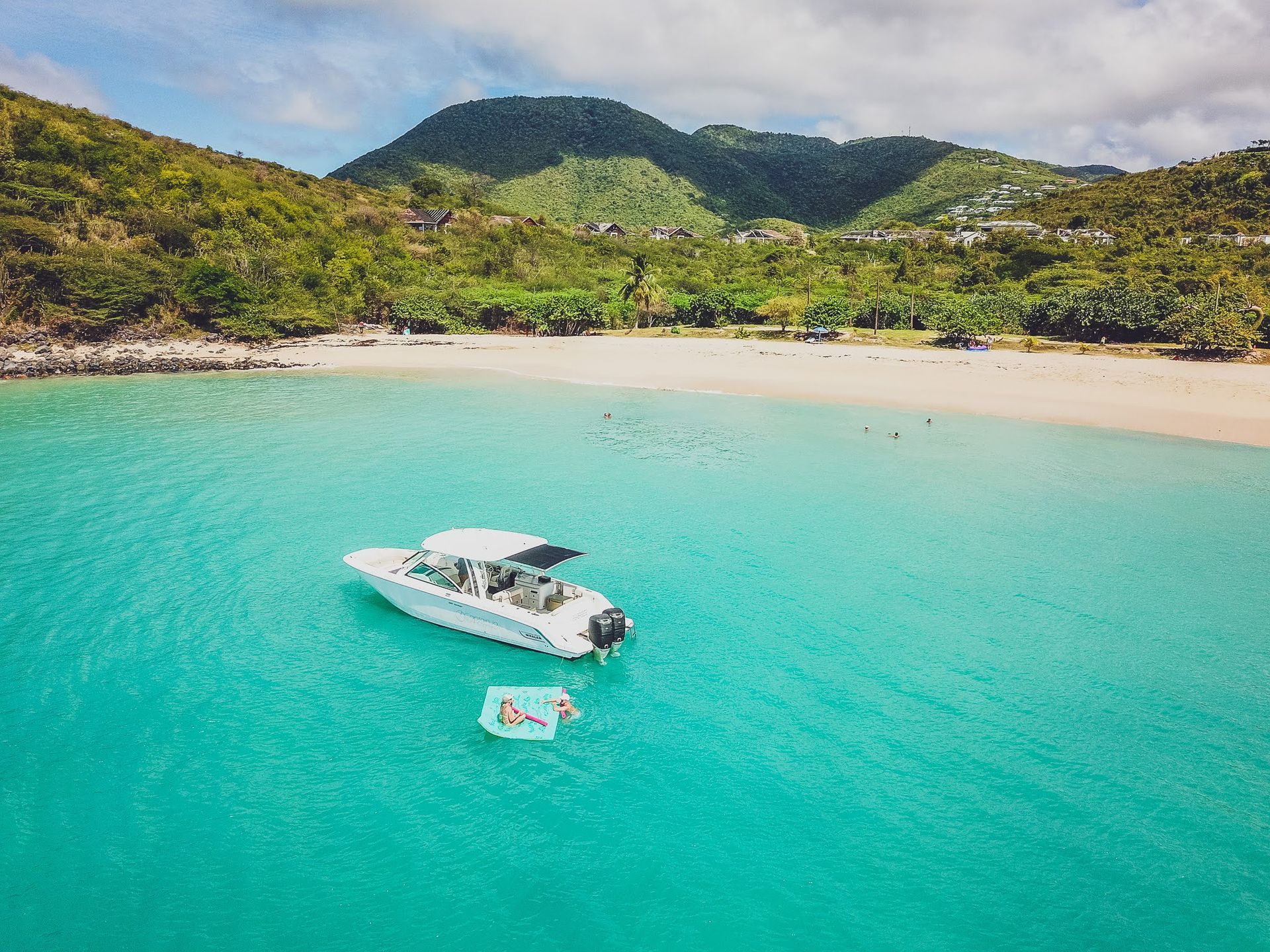 An aerial view of a boat in the ocean near a beach.