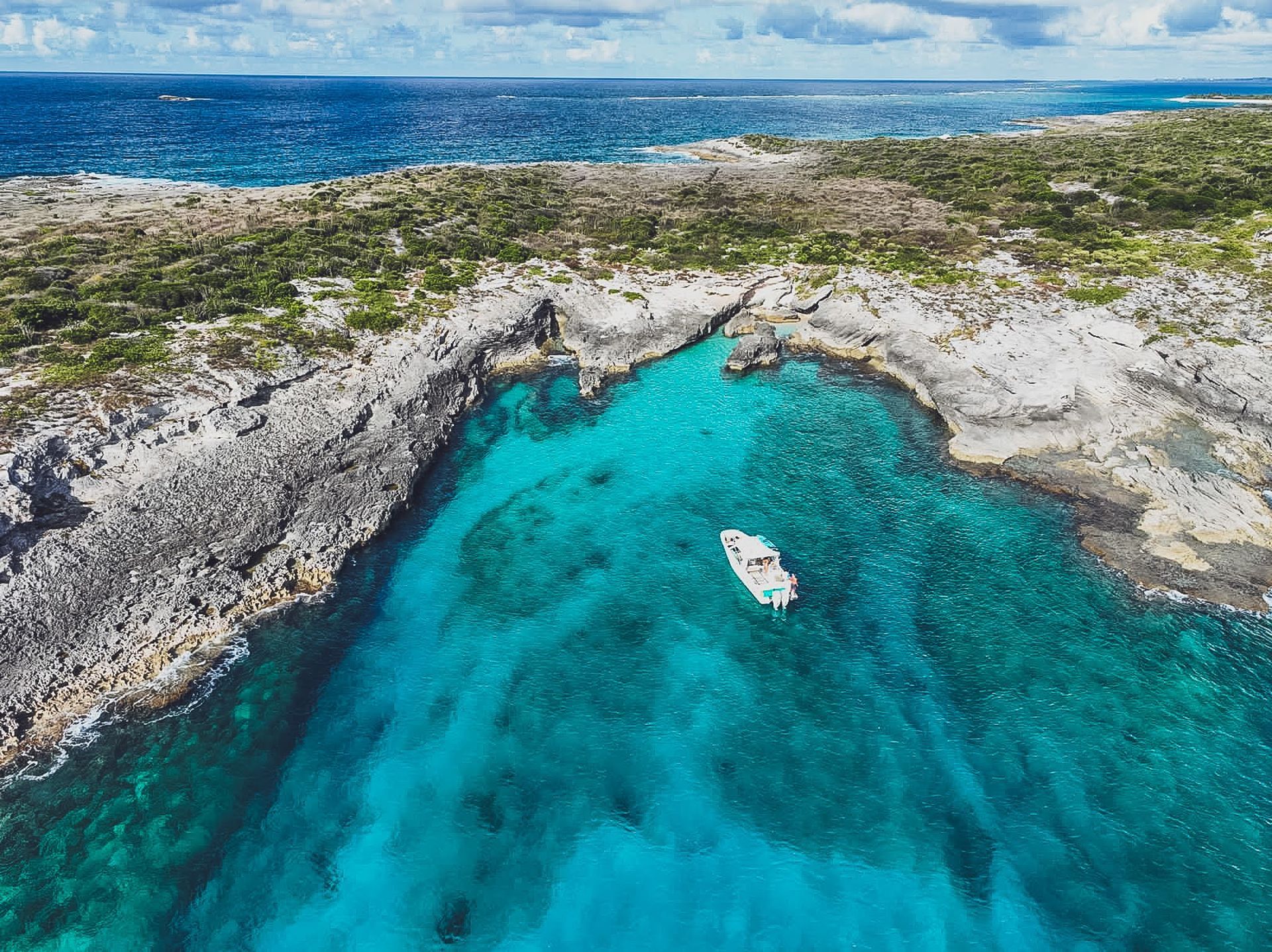 An aerial view of a boat in the middle of a body of water.