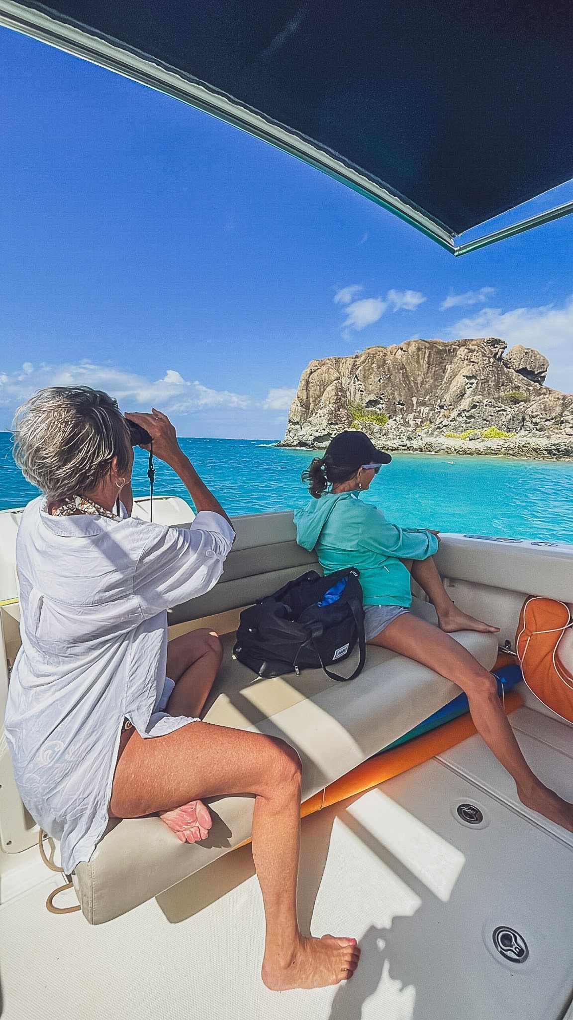 Two women are sitting on a boat in the ocean.
