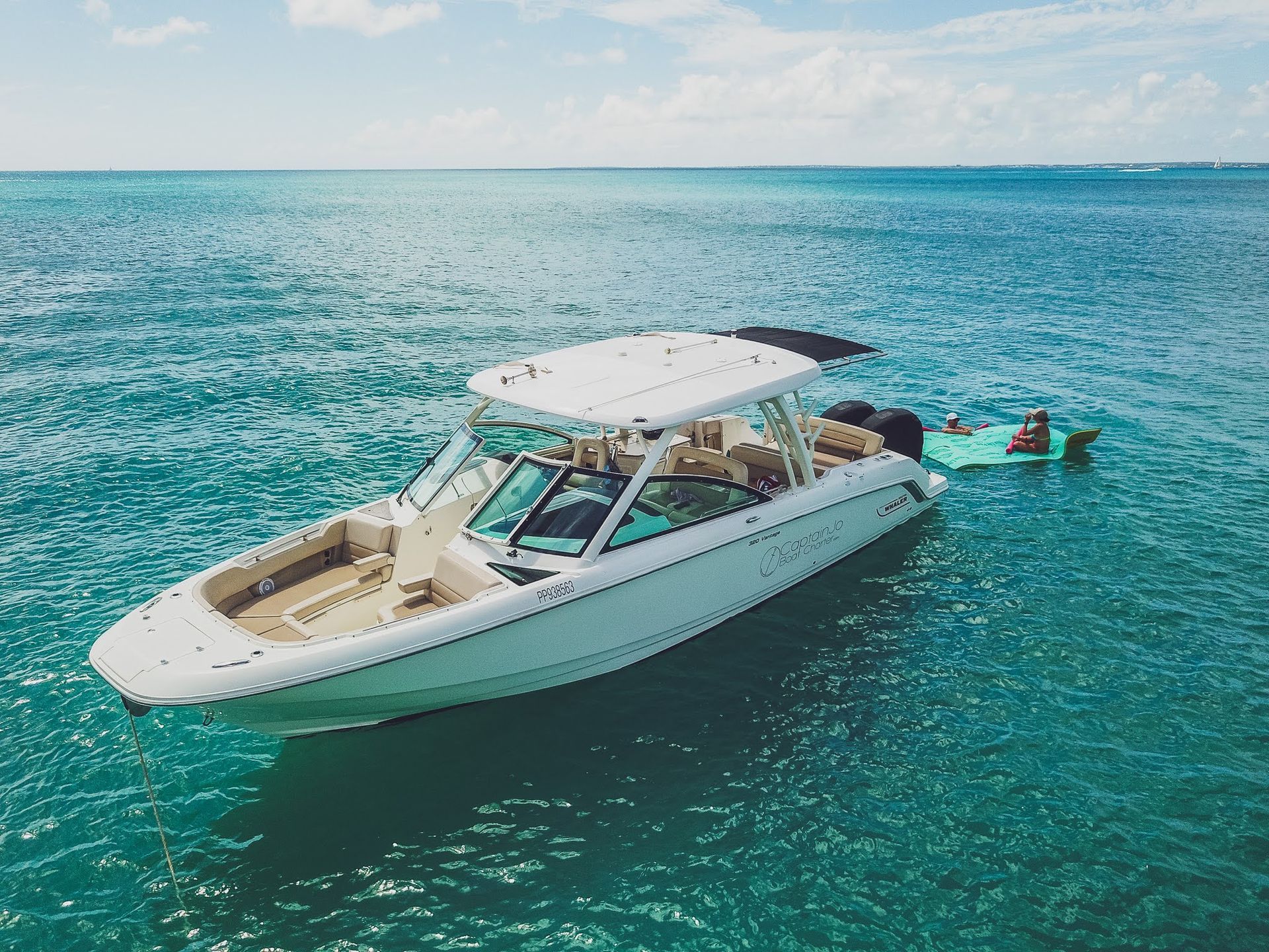 A white boat is floating on top of a large body of water.