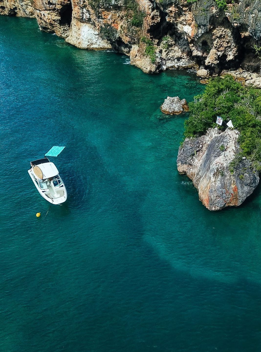 An aerial view of a boat in the middle of a body of water.