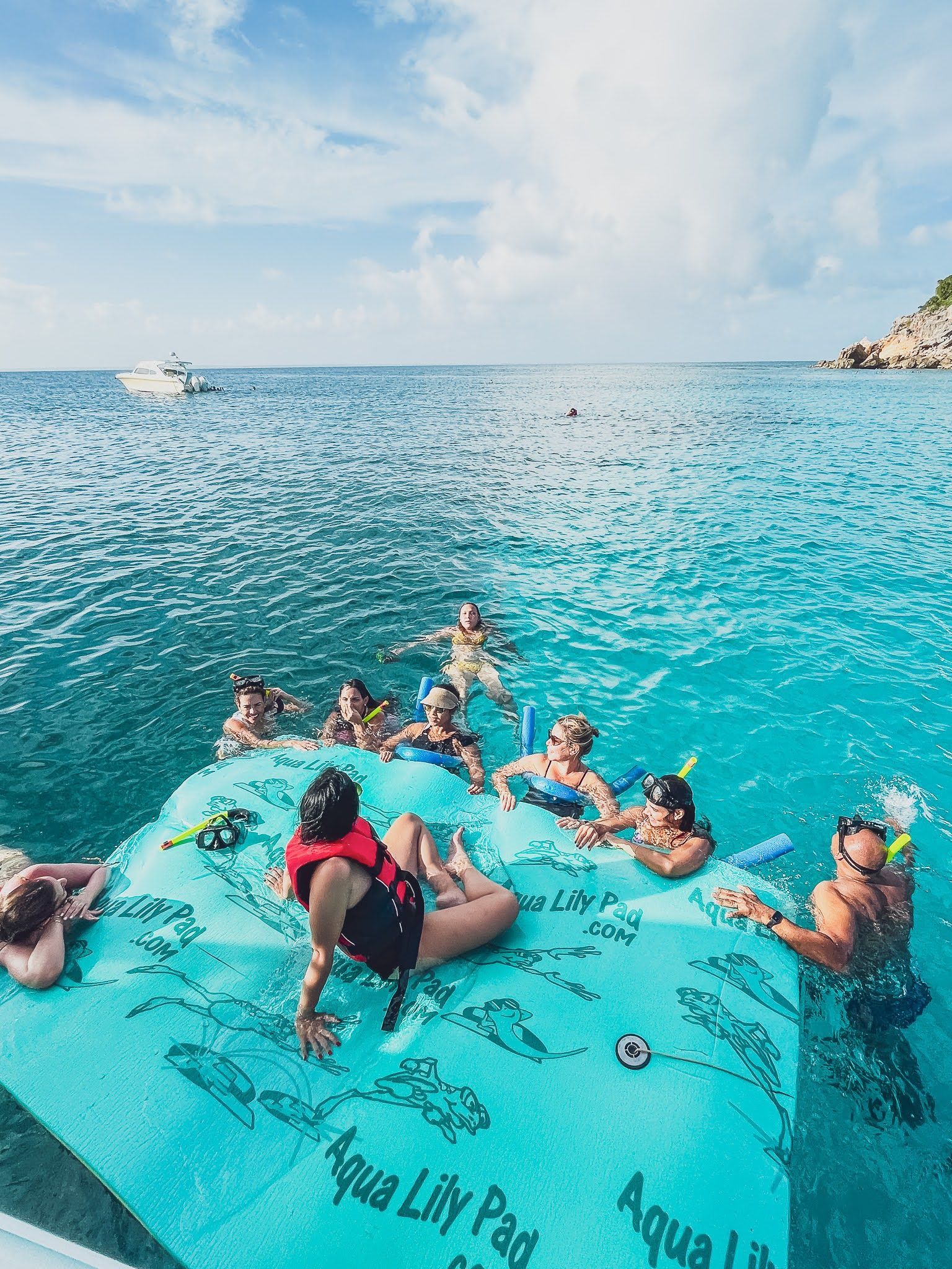 A group of people are floating on a raft in the ocean.