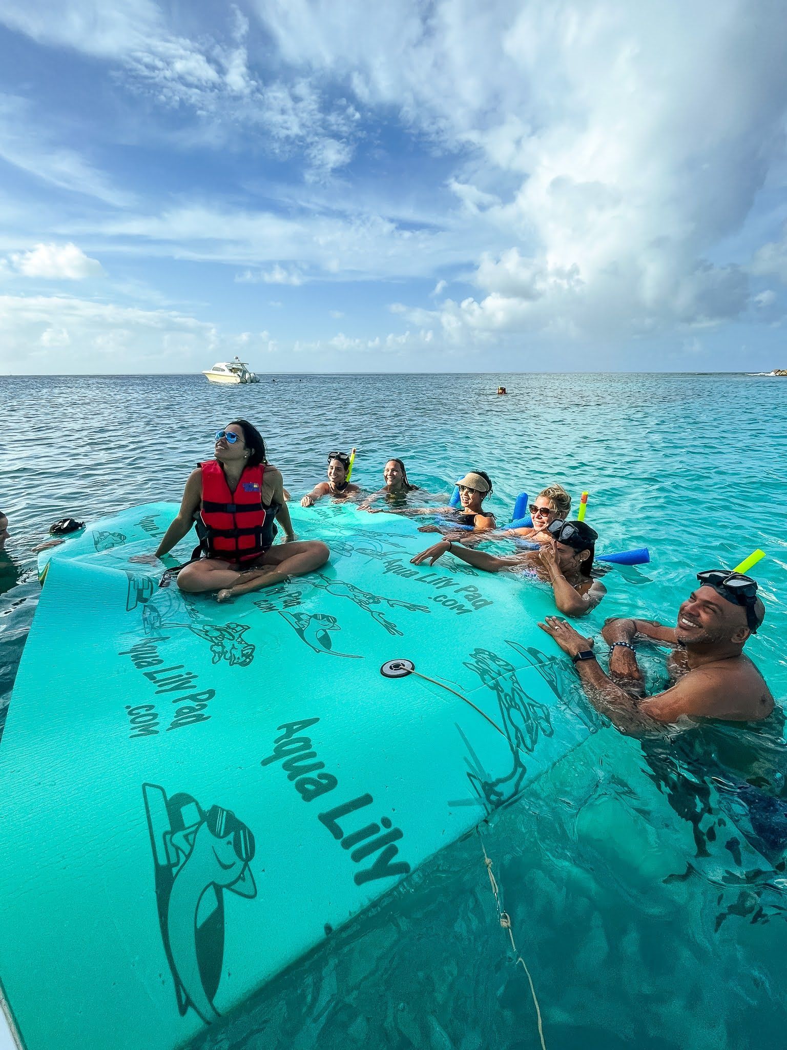 A group of people are floating on a raft in the ocean.