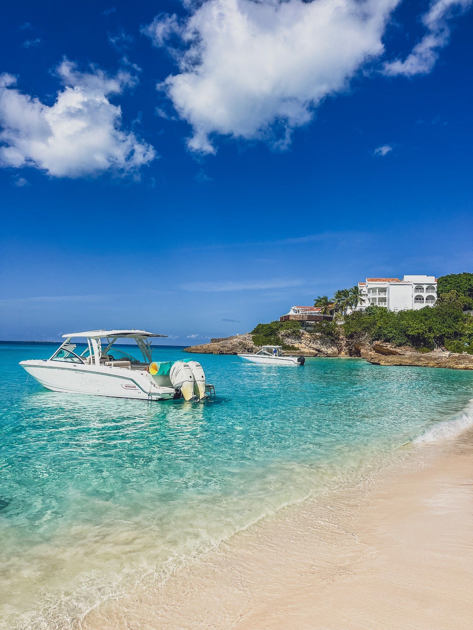 A boat is floating on the water near a beach.