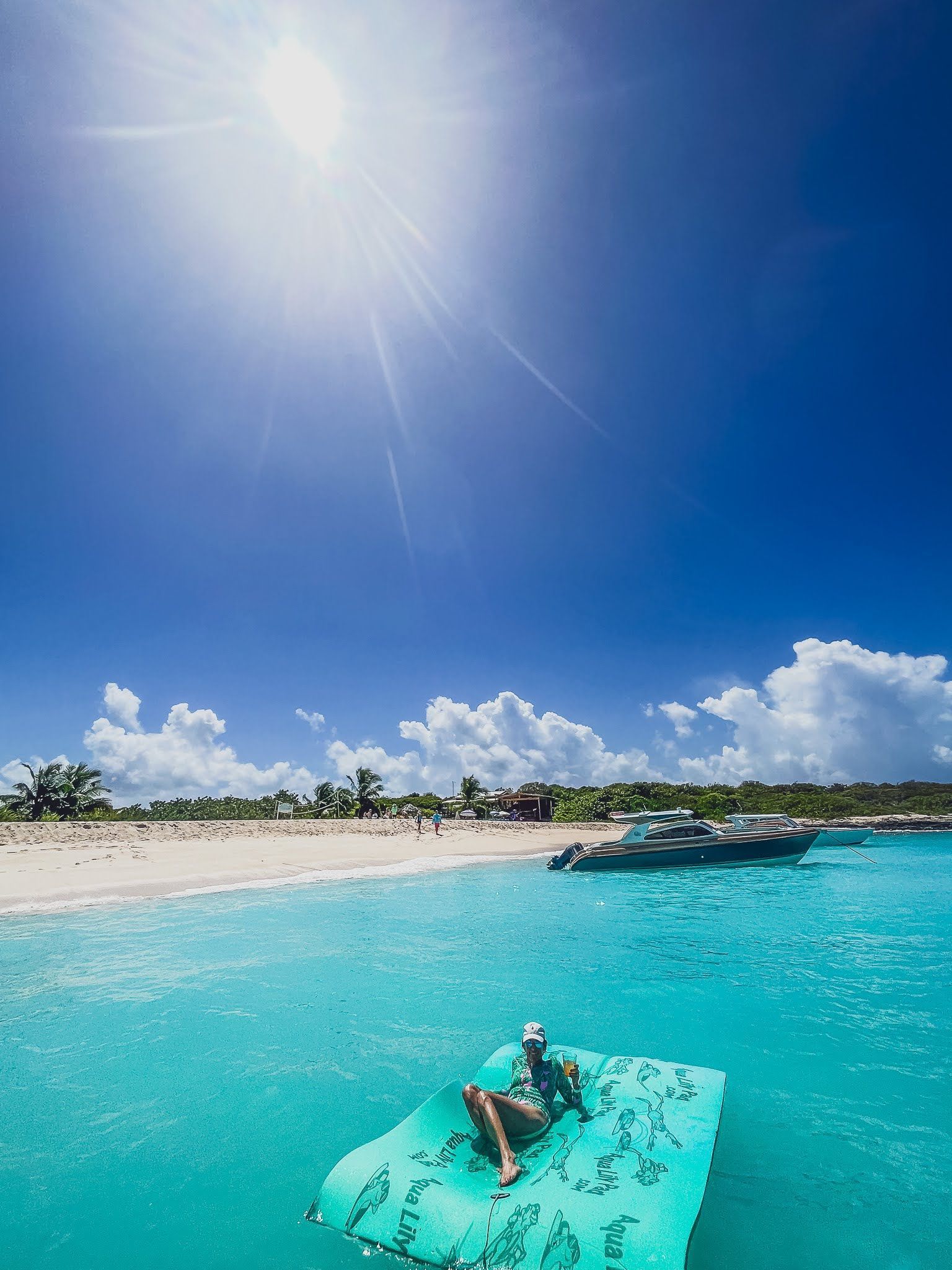 A person is laying on a raft in the ocean.