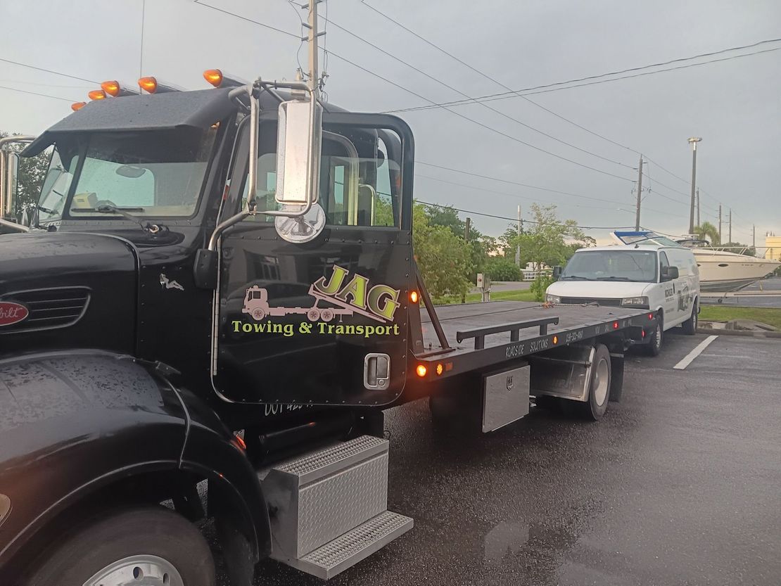 A black flatbed tow truck with 
