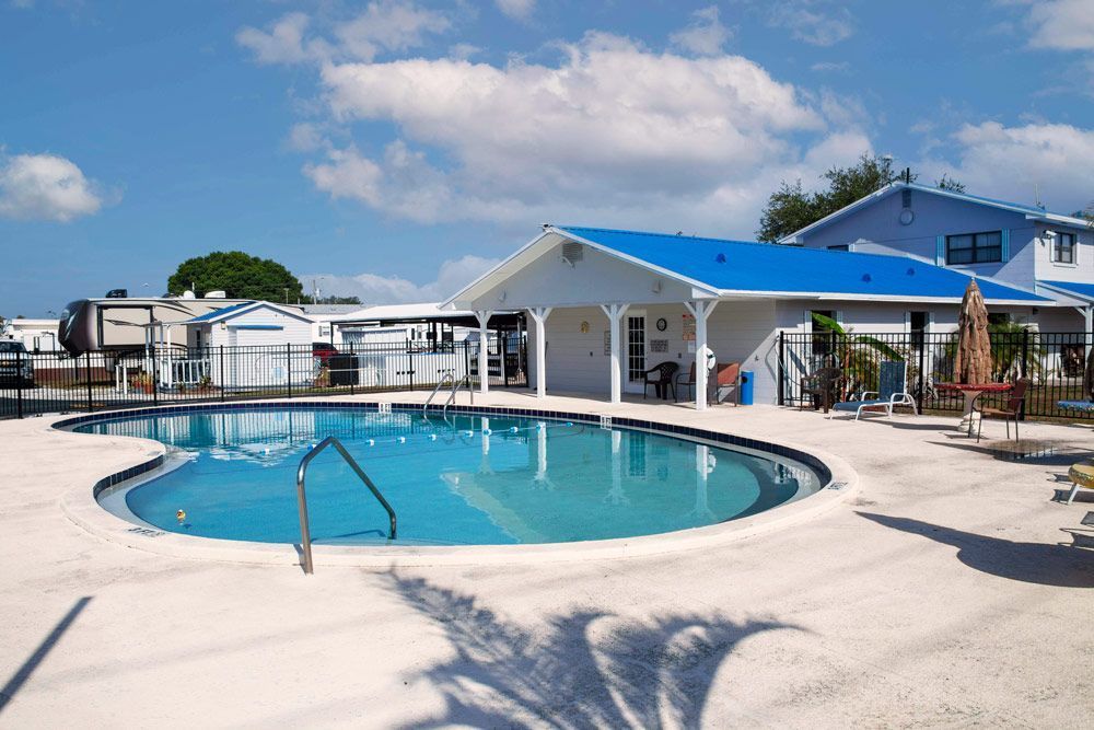 Swimming pool next to a building with a blue roof on a sunny day.