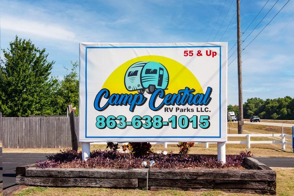 Sign for Camp Central RV Parks LLC, 55 & Up, with RV illustration and phone number.