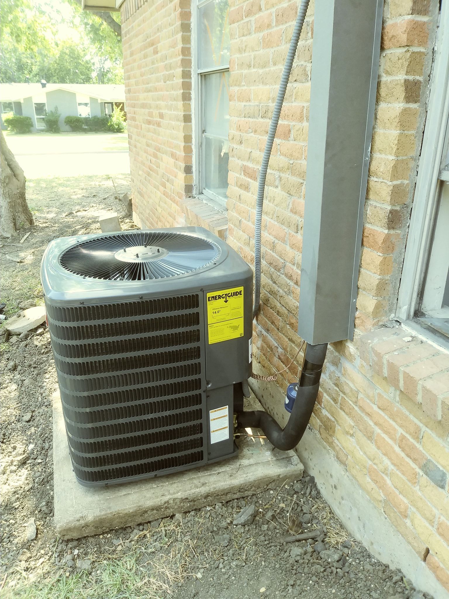 an air conditioner is sitting on the side of a brick building .