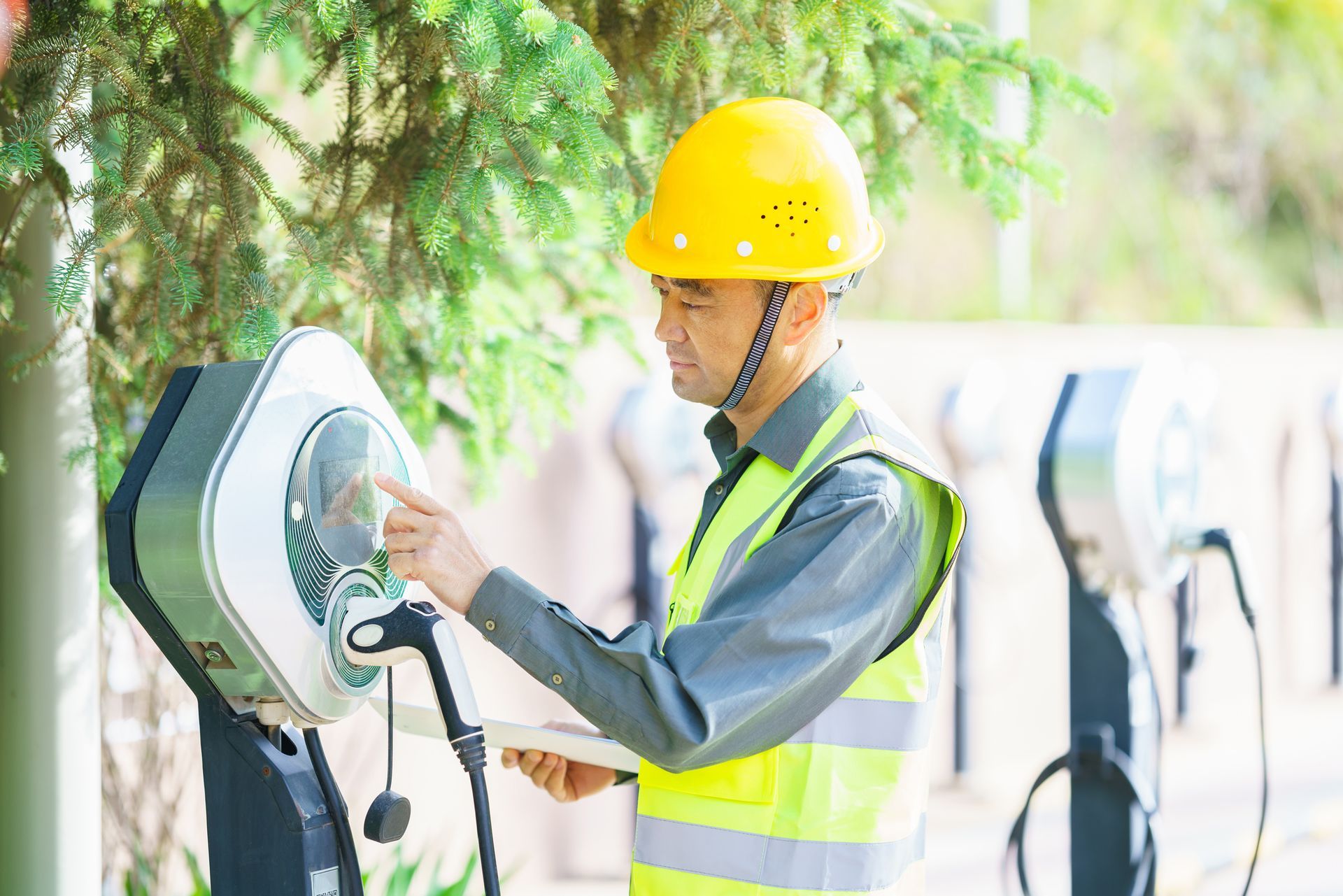 Electrical technician working at electric vehicle charging station 
