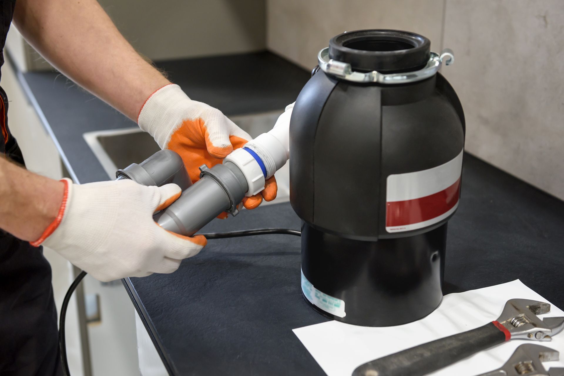 A man is fixing a garbage disposal in a kitchen.