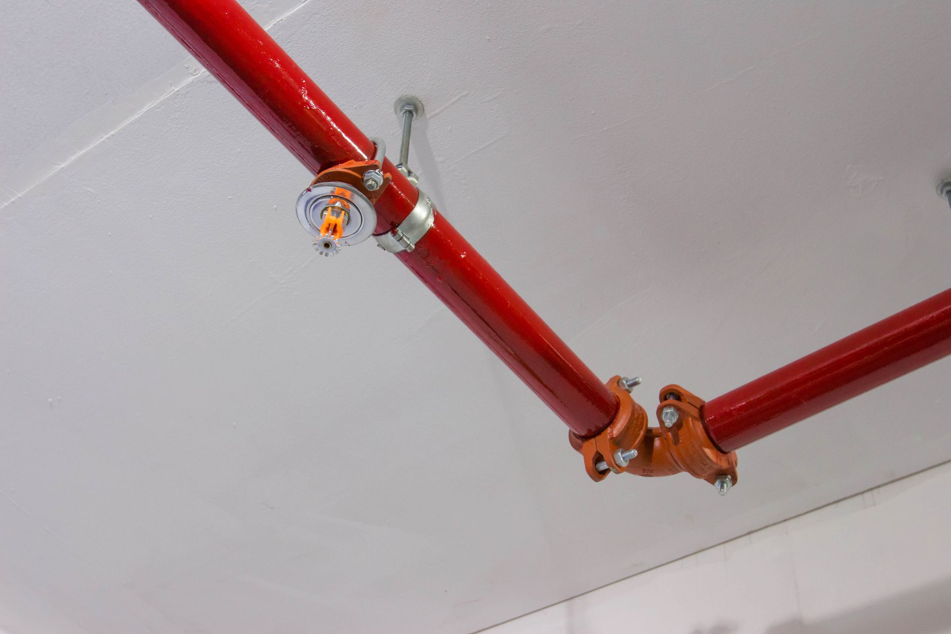 A fire sprinkler is hanging from the ceiling of a building.