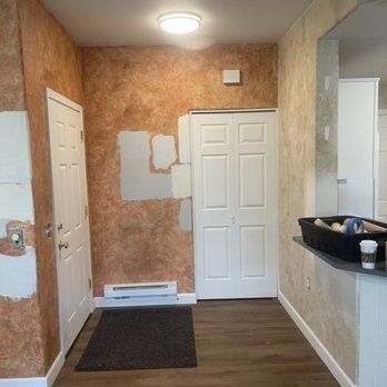 A hallway with a door and a rug in a house.