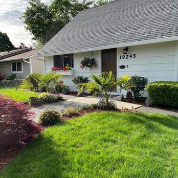 A white house with a lush green lawn in front of it.