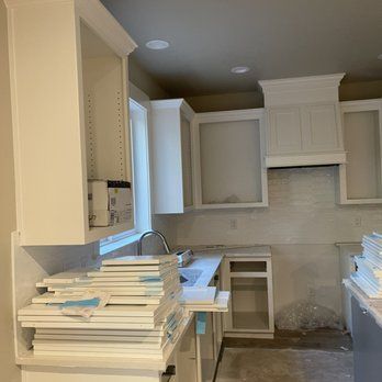 A kitchen under construction with a stack of books on the counter.
