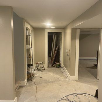 A hallway with a ladder and a stool in it.