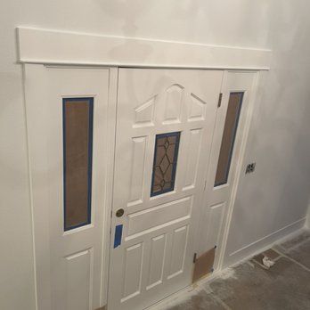 A white door with a stained glass window is in a room.