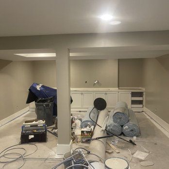 A basement is being remodeled and there is a lot of stuff on the floor.