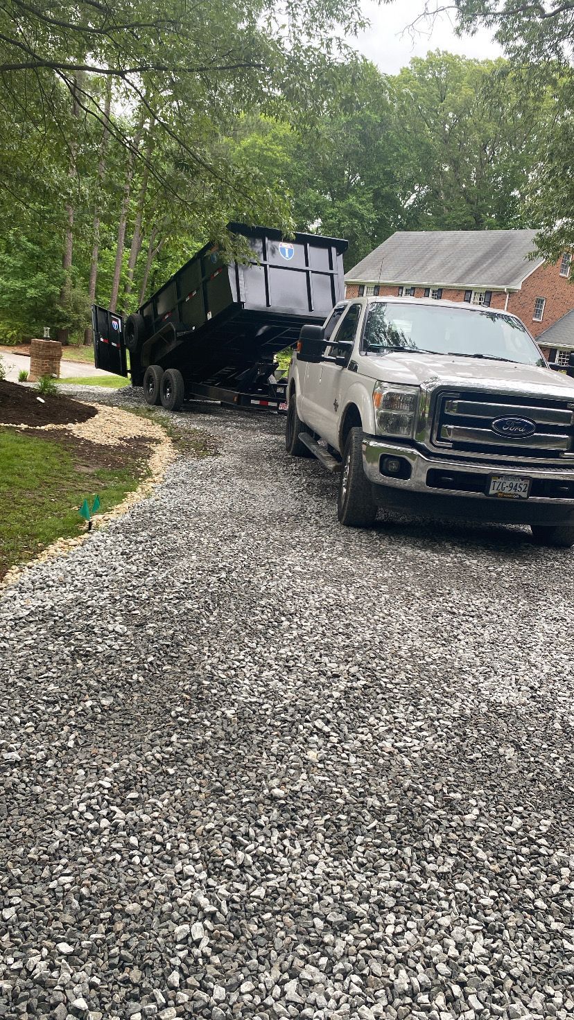 A white pickup truck with a black trailer on a gravel driveway, in front of a house.
