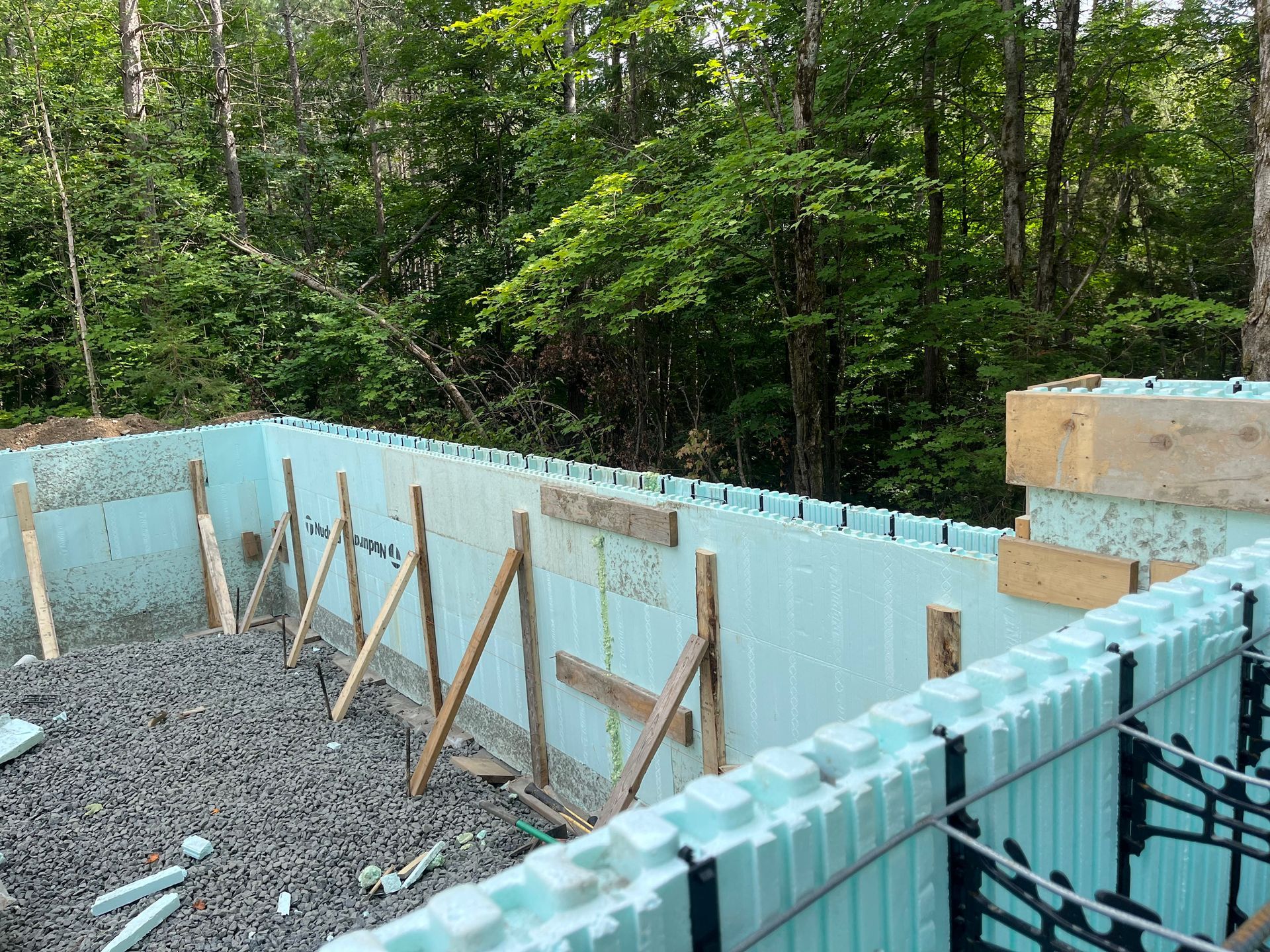 A blue wall is being built in the middle of a forest.