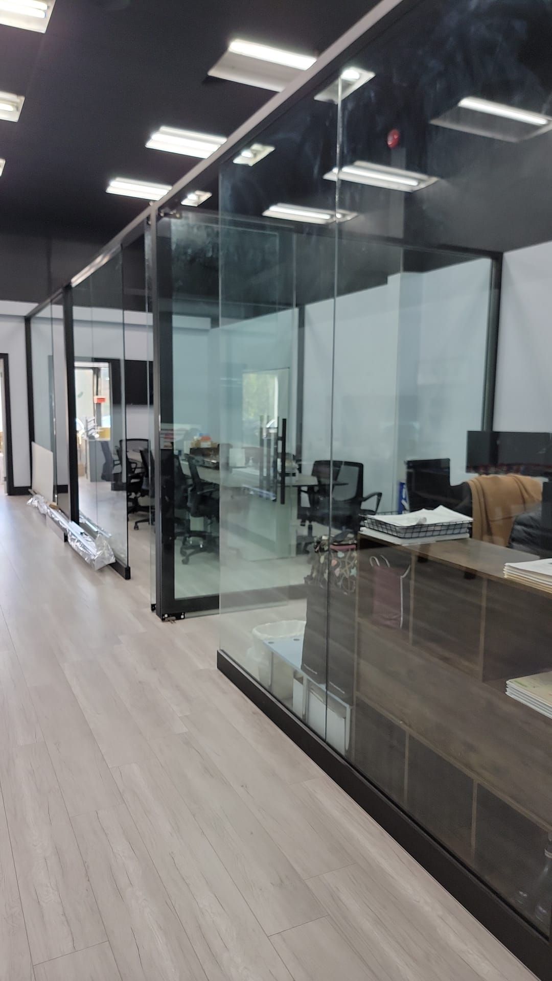 A large office with a lot of glass walls and dividers.