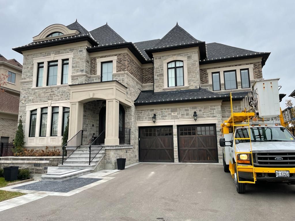 A large house with a yellow truck parked in front of it.