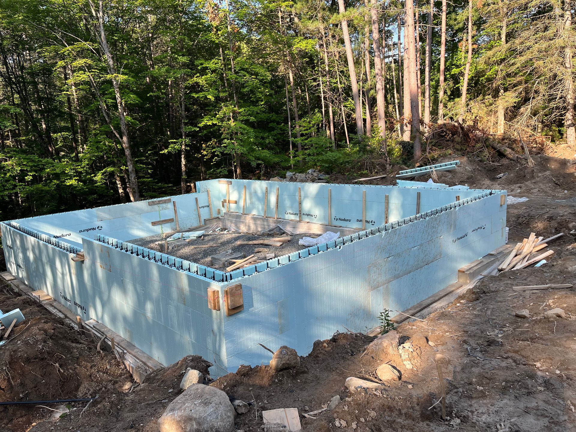 A swimming pool is being built in the middle of a forest.