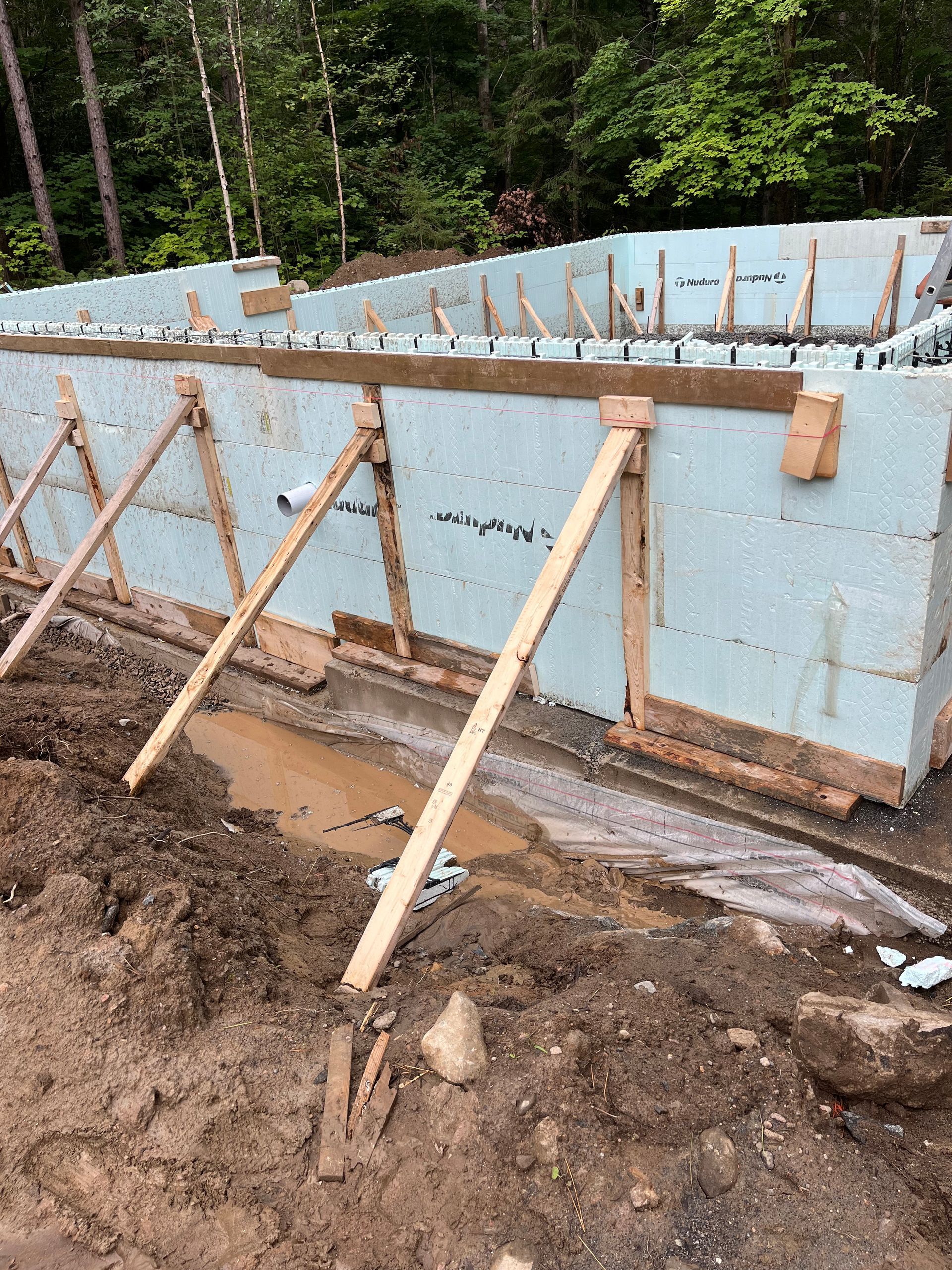 A building is being built in the middle of a muddy field.