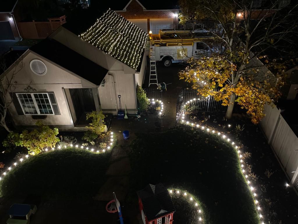 An aerial view of a house decorated with christmas lights at night.