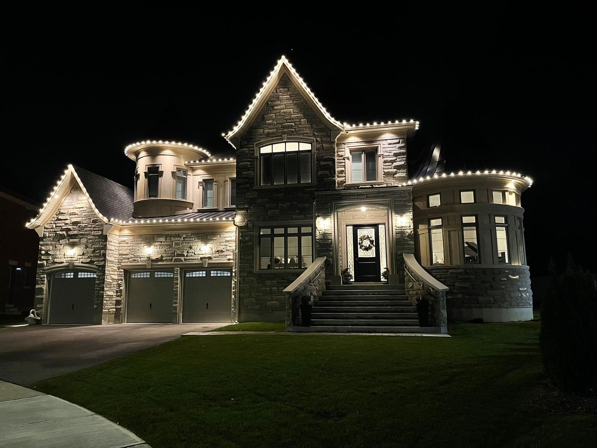 A large house is lit up at night with christmas lights