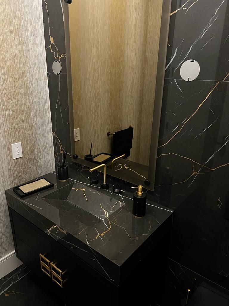 A bathroom with a sink , mirror and soap dispenser.