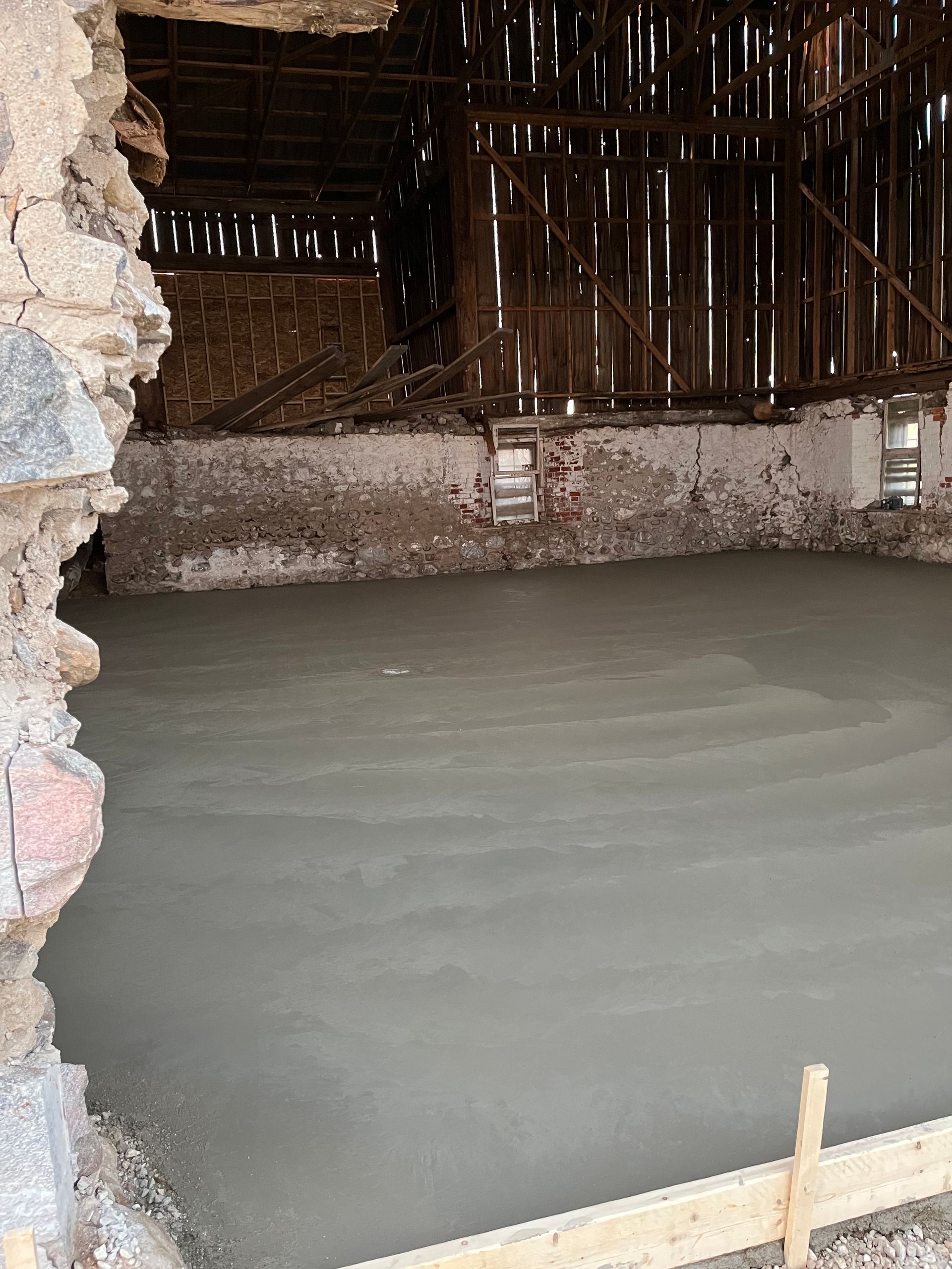 A concrete floor is being built in a barn.