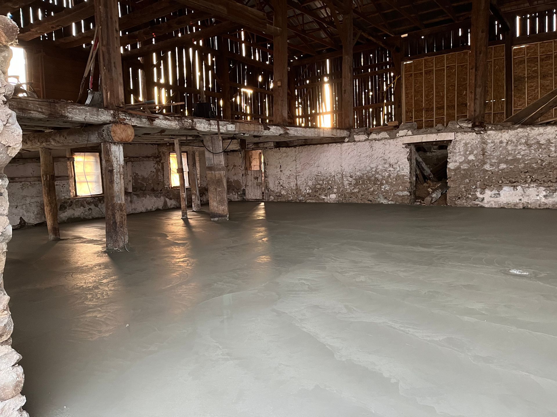 There is a concrete floor in the middle of a barn.