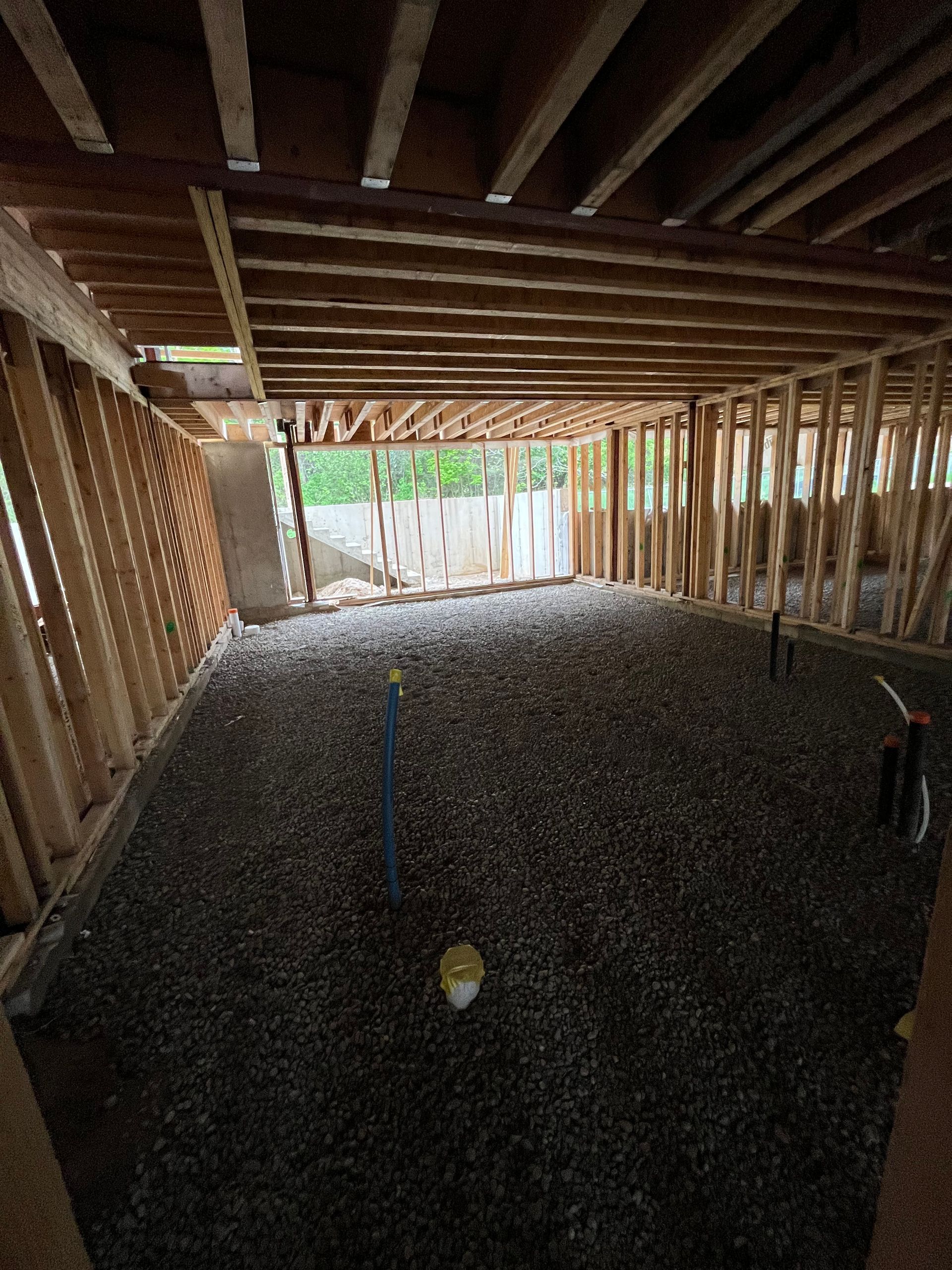 The inside of a building under construction with gravel on the floor.