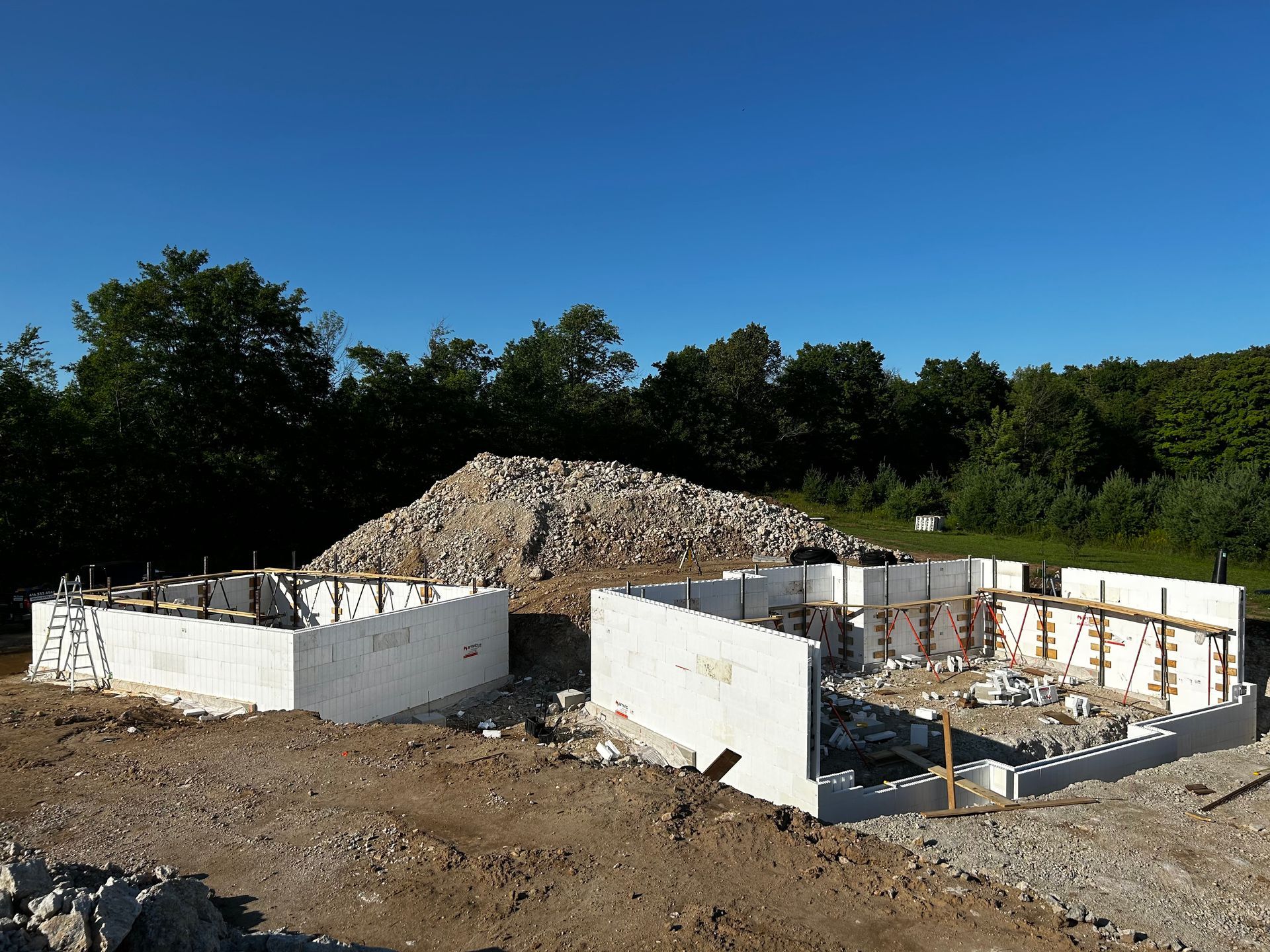 A building under construction with a pile of dirt in the background