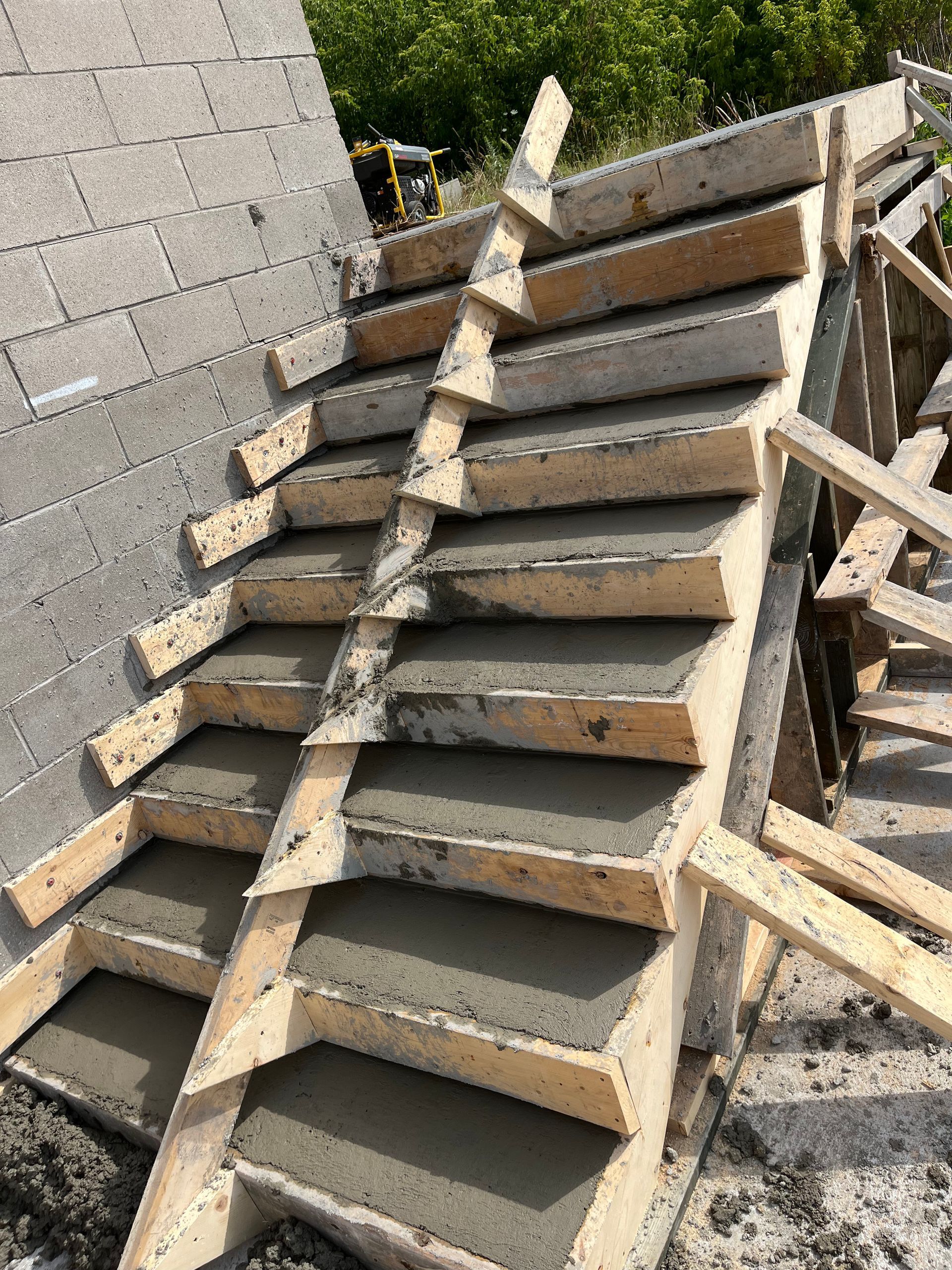 A concrete staircase is being built on top of a brick wall.