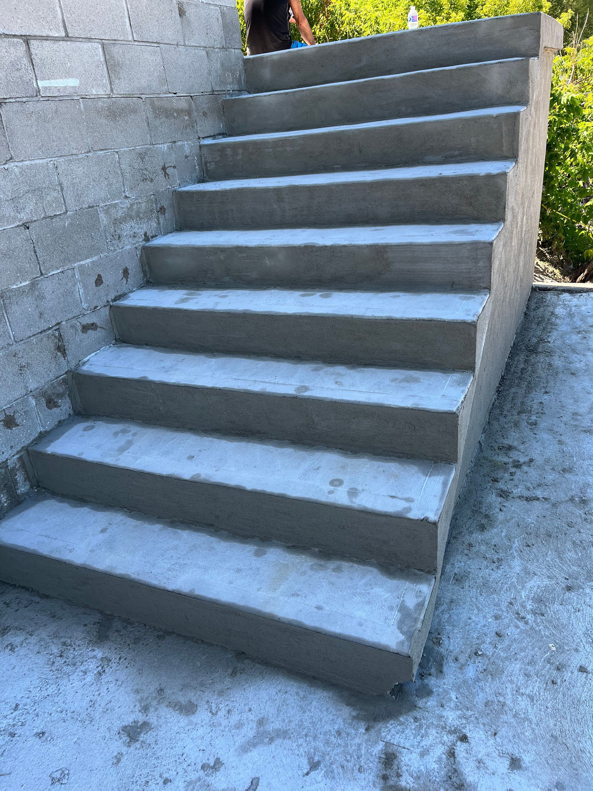 A set of concrete stairs leading up to a brick wall