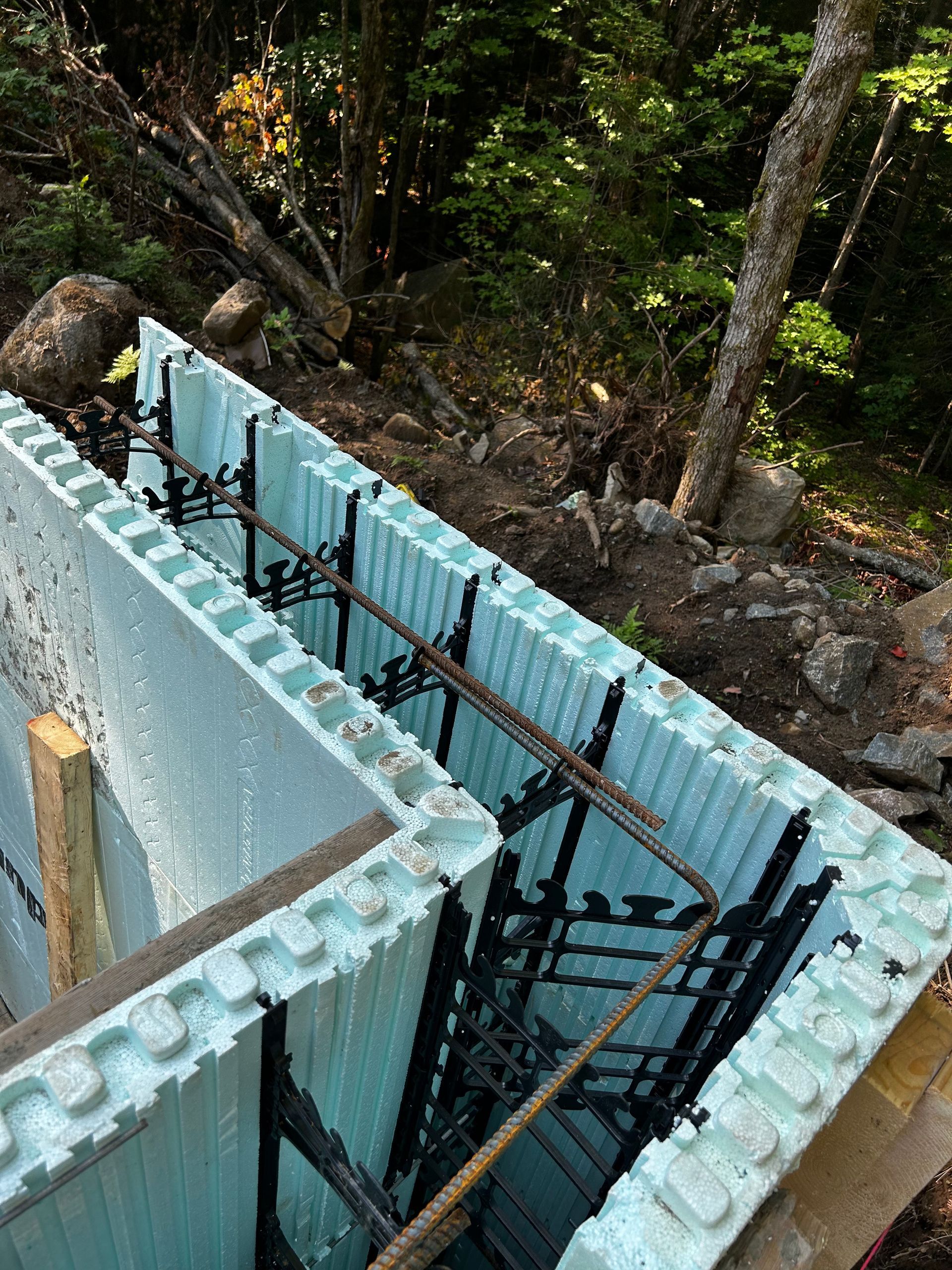 A concrete wall is being built in the woods.