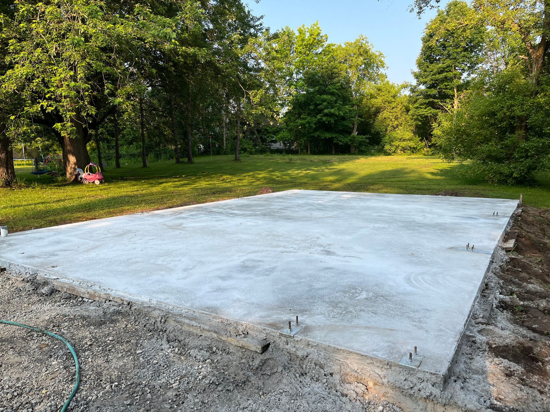 A large concrete slab is sitting in the middle of a grassy field.