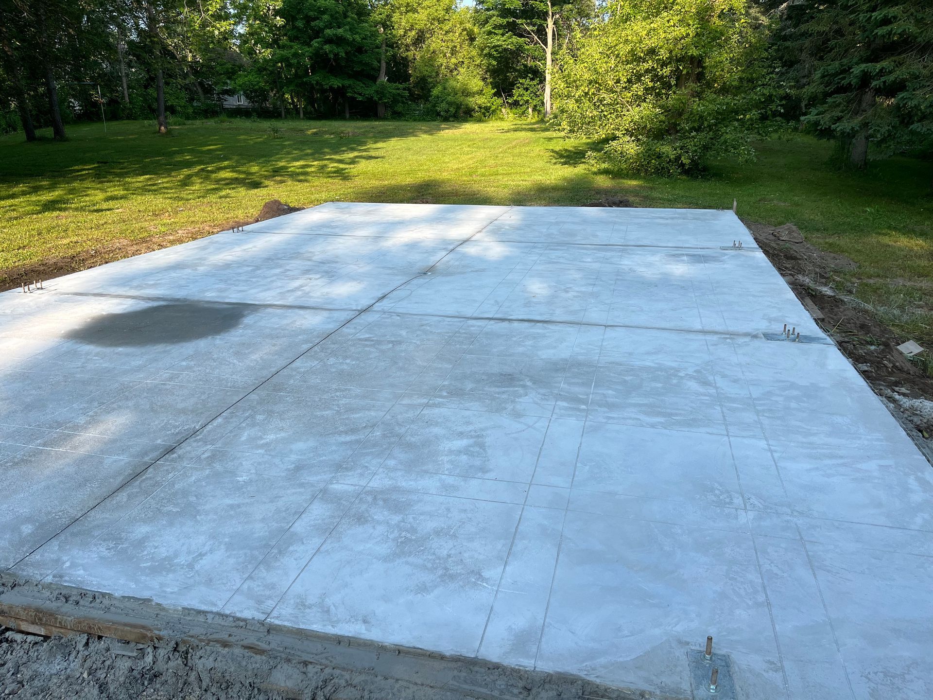 A large concrete slab is sitting in the middle of a grassy field.