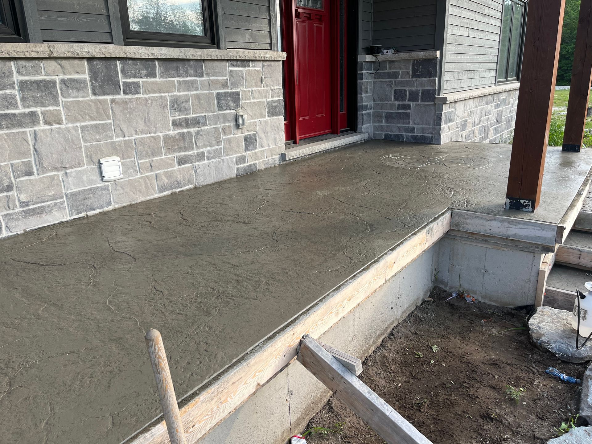 A concrete porch is being built on the side of a house.